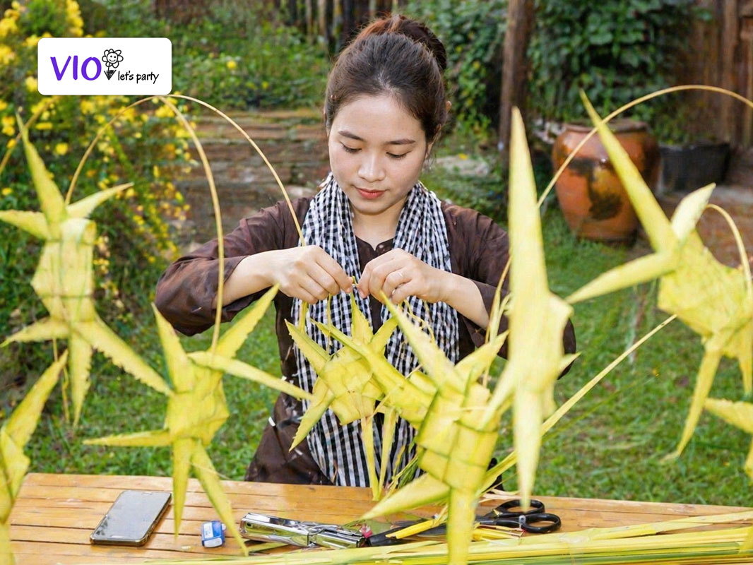 Nghệ nhân gấp lá dừa VioParty đang tạo hình cào cào cho các bé